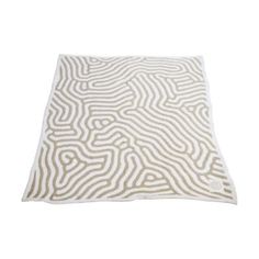 a white and beige rug with wavy lines on the bottom, in front of a white background