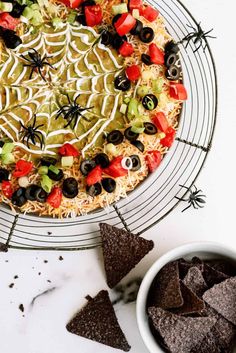 a spider web pizza with black olives and tomatoes