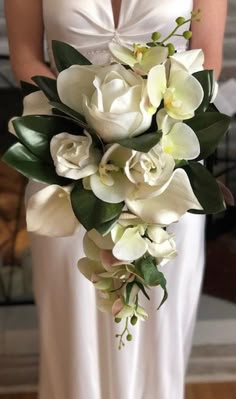 a bride holding a bouquet of white flowers