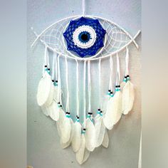 a white dream catcher with an evil eye on it