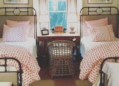 two twin beds with pink and white bedding in a bedroom next to a window