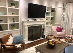 a living room filled with furniture and a flat screen tv mounted on a wall above a fire place