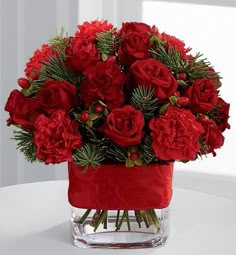 a vase filled with red flowers on top of a table