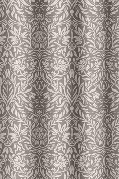 a gray and white shower curtain with an ornate design on the bottom half of it