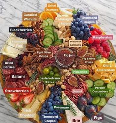 a plate filled with different types of fruits and vegetables on top of a marble table