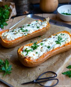 two baked breads with cheese and herbs on a cutting board