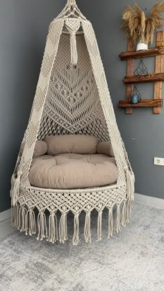 a hammock hanging from the ceiling in a room with gray walls and flooring