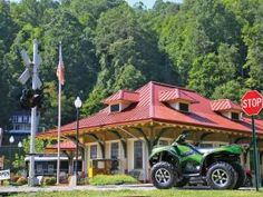 a green four wheeler parked in front of a stop sign