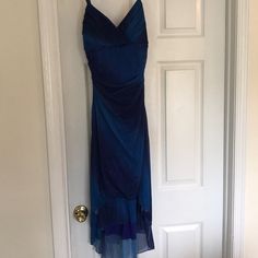 a blue dress hanging up on a door