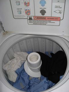 a washing machine with clothes in it and instructions on how to use the washer