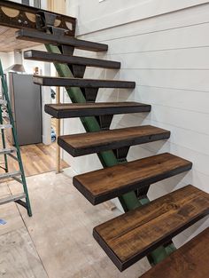 a set of stairs made out of wooden planks in a house with white walls