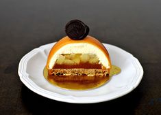 a dessert on a white plate with an oreo in the center and caramel