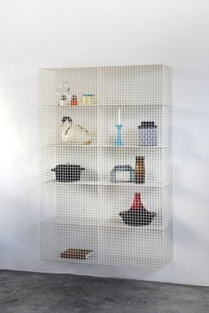 a white shelf filled with hats and vases on top of it's sides