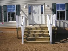 a white door and some steps in front of a house