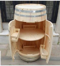 a wooden barrel shaped like a boat with shelves on the front and side sides, sitting outside