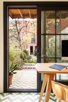 an open door leading to a patio with potted plants on the table and in front of it