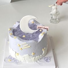 someone is decorating a cake with the moon and stars