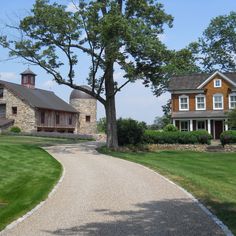 two large brown houses sitting on top of a lush green field