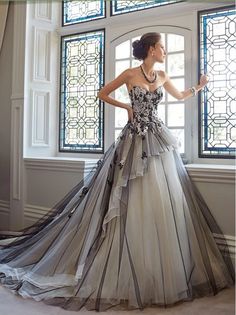 a woman standing in front of a window wearing a dress