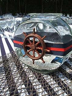 there is a glass bowl with a ship's wheel in it on the table