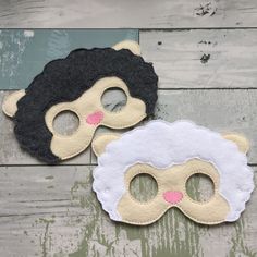 two masks with black and white sheeps on them, one has pink nose and the other has brown eyes