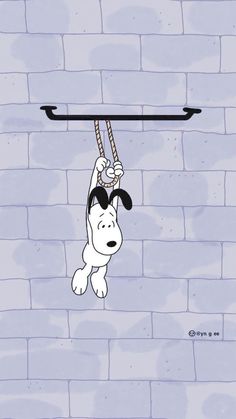 a cartoon dog hanging from a rope on a brick wall