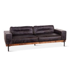 a brown leather couch sitting on top of a wooden frame