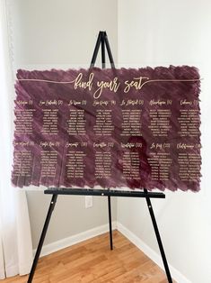 a purple and gold wedding seating chart on a easel