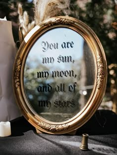 a mirror that is sitting on top of a table with some writing in the reflection