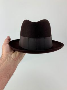 Vintage 1940'S-50'S chocolate brown wool felt fedora with a wide grosgrain ribbon band.  This is a ROYAL STETSON FEDORA manufactured by the John B Stetson Company on one side of the leather sweatband is printed: Melvin E. Beck Hub Clothing Co. Moorhead The other side is printed: ROYAL STETSON This fedora is in EXCELLENT VINTAGE CONDITION... with no signs of wear. This is in MINT CONDITION NOS DEADSTOCK The leather sweatband is perfect.. and the lining is beautiful with a satin checked fabric on the inside... SIZE: MEN'S SIZE 7-1/8 Measurements: Inside measure along the sweatband is approximately 22-1/2 inches Brim is 2-1/4 inches wide Stack is approximately 4-1/4 inches tall at the crease. The grosgrain ribbon band is  2 inches wide Vintage Brown Fedora For Formal Occasions, Classic Brown Formal Hat Band, Vintage Formal Hat Bands, Vintage Formal Hat Bands In Solid Color, Classic Brown Wool Fedora, Formal Fitted Brown Fedora, Retro Fitted Fedora With Curved Brim, Retro Fedora With Curved Brim, Fitted Retro Fedora With Curved Brim