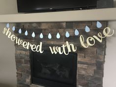 a fireplace decorated with paper rain drops and the words, sheweded with love