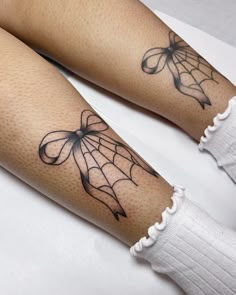 two legs with spider web tattoos on them, one is black and the other is white