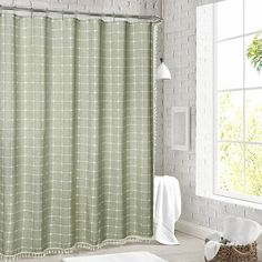 a bathroom with a green shower curtain next to a window