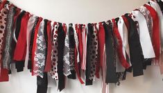 a bunch of scarves hanging on a wall next to a white wall with red and black polka dots