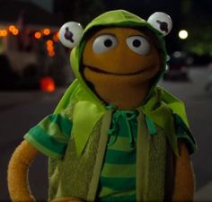 the muppet is dressed in green and has two eyes