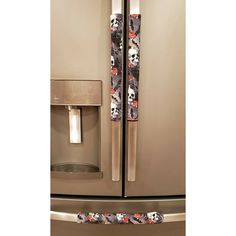 a stainless steel refrigerator with skulls and flowers on the door handle is shown in this image