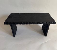 a black wooden bench sitting on top of a white background