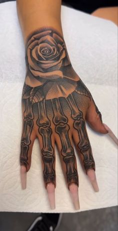 a woman's hand with tattoos on it and a rose tattooed on the palm