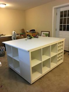 a large white book shelf in the middle of a room with other items on it