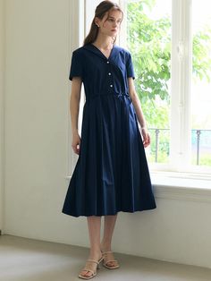 The Sailor Collar Dress offers a charming and timeless design, perfect for both casual and semi-formal occasions. This product features a distinctive sailor collar that adds a nautical touch to the elegant floral pattern. Its flowing skirt and fitted waist create a flattering and feminine silhouette. - This Sailor Collar Dress is designed with a classic sailor collar, providing a unique and elegant detail.- The dress features a floral pattern that adds a touch of femininity and charm.- Its fitted waist and flowing skirt ensure a flattering and comfortable fit.- A handmade Cali medal decoration has been attached to the lower right side of the front panel to add a unique point of interest. Classic Navy Midi Dress, Navy Short Sleeve Classic Dress, Navy Fitted Collared Dress, Navy Classic Short Sleeve Dress, Casual Collared Dress With Pleated Waist, Classic Navy A-line Dress, Spring Sailor-style Short Sleeve Dresses, Navy Collared Dress For Spring, Spring Navy Collared Dress