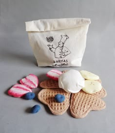 some kind of waffles and ice cream on a gray table with a bag