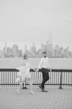 a man and woman are holding hands near the water