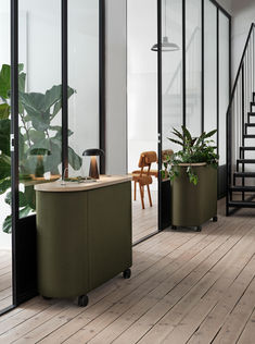 an office with two planters on the floor and a staircase leading up to it