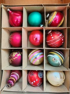 an open cardboard box filled with different colored ornaments