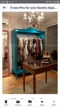 a blue cabinet with clothes hanging on it and a chandelier in the background