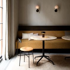 a couch and table in a room with two lamps on the wall above it,