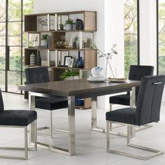 a dining room table with chairs around it and shelves on the wall in the background