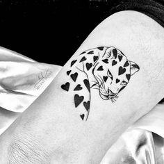 a black and white photo of a leopard with hearts on it's leg