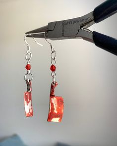 Looking for the perfect spooky accessory to complete your Halloween look? These bloody cleaver earrings are the ideal choice for horror fans and those who love making a statement with their jewelry. Crafted with attention to detail, these lightweight earrings feature a mini cleaver coated in a blood-splattered effect, accented by red beads. They're the perfect addition to any Halloween costume or horror-themed event, or even as a bold accessory for any day you want to channel a spooky vibe. Great for gifting to Halloween lovers, horror enthusiasts, or those who appreciate unique, edgy jewelry. These bloody cleaver earrings will surely be a conversation starter at any spooky gathering. Length: Approx. [1 1/2 - 2in] Materials: [ metal alloy, bicone beads] Closure: Fishhook style Handmade wit Mini Cleaver, Shifting Script, Edgy Jewelry, Halloween Lovers, Earrings Halloween, Funky Earrings, Halloween Costume Accessories, Bold Accessories, Red Beads