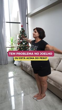 a woman standing in front of a christmas tree